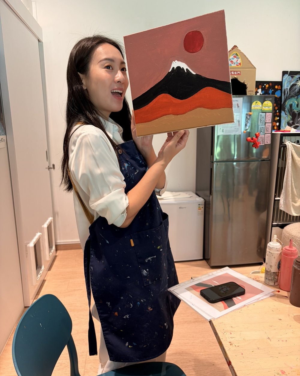 Tracy Lo holding one of her own paintings